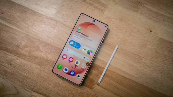 A smartphone with a stylus rests on a wooden surface.