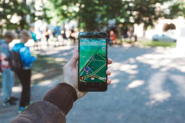 Photo by David Grandmougin person playing Pokemon Go during daytime